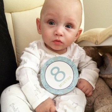 Malachi at 8 months old. Again-not too sure about taking pictures. But isn't that face the cutest? He is supported sitting in this picture. Something he could not do at 7 months.